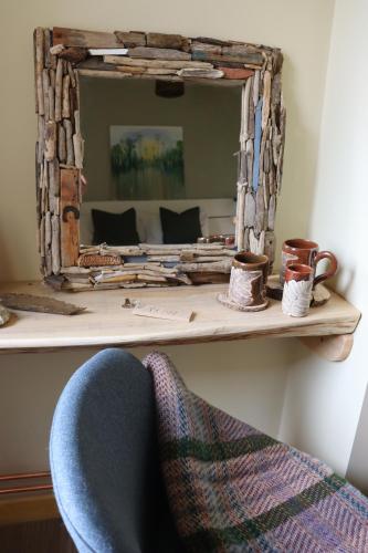 a mirror sitting on a shelf next to a chair at South Downs Eco Lodge & Camping in East Meon