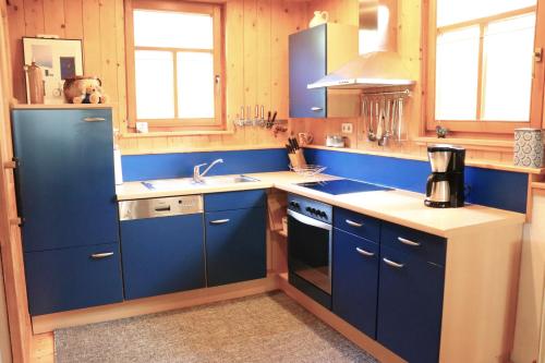 a kitchen with blue cabinets and a sink at Ferienunterkünfte Deinhardt in Poxdorf