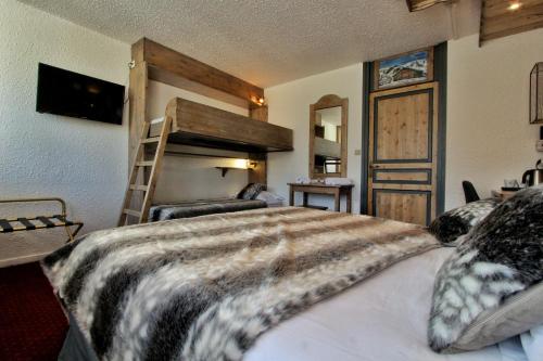 a bedroom with a bed and a bunk bed at Hotel Le Pelvoux in Les Menuires