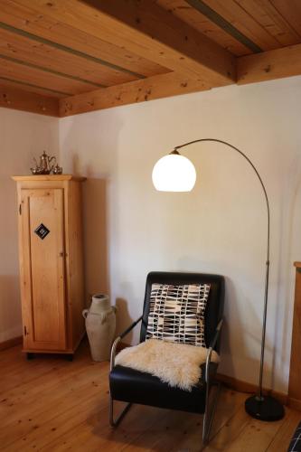 a room with a black chair with a rug on it at Ferienunterkünfte Deinhardt in Poxdorf
