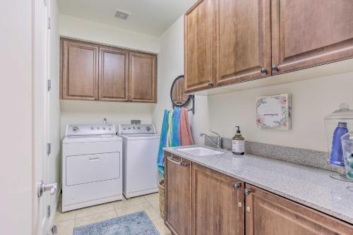 cocina con lavadora, secadora y armarios de madera en Desert Views and Pool Access Home in La Quinta!, en La Quinta