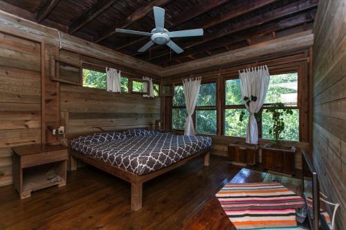 a bedroom with a bed and a ceiling fan at Roatan Bed & Breakfast Apartments in West End