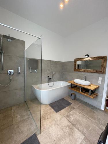a bathroom with a bath tub and a sink at Stadtvilla Füssen in Füssen