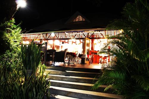 a restaurant at night with stairs in front of it at Pirogue Lodge in Baie Sainte Anne