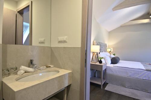 a bathroom with a sink and a bed at Hotel Florian&Godler in Karlovac