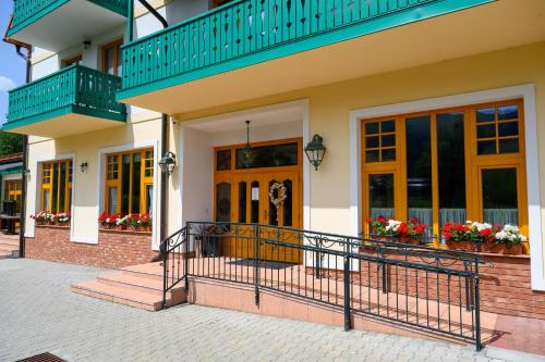 a house with a balcony and flowers in windows at Hotel Julianin dvor in Habovka