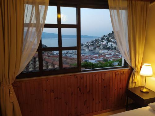 a bedroom with a window with a view of a city at Hydra's View House in Hydra