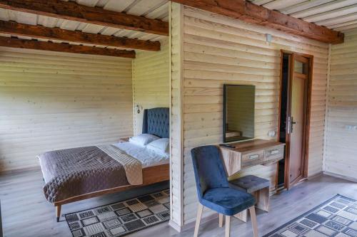 a bedroom with a bed and a desk and a chair at Шаян Гора in Shaian