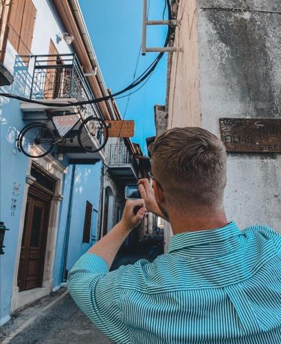 a man talking on a cell phone on a building at Lazaros Stonehouse in Pano Lefkara