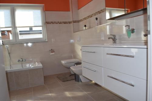 een witte badkamer met een toilet en een wastafel bij Ferienhaus 1 in Göbenhausen