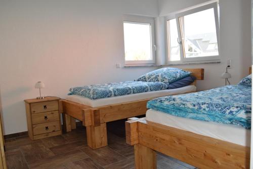 ein Schlafzimmer mit zwei Einzelbetten und einem Fenster in der Unterkunft Ferienhaus 1 - 55483 Unzenberg in Göbenhausen