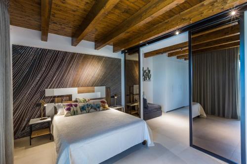 a bedroom with a large bed and a glass wall at Radici Luxury B&B in Monsampolo del Tronto