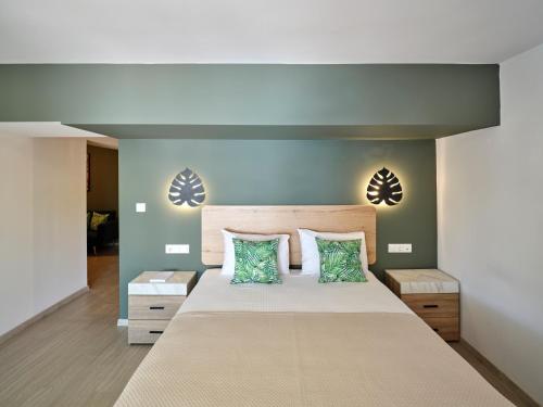 a bedroom with a large bed with two pillows at The Tree Suites in Skiathos