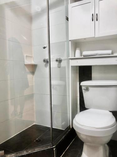 a bathroom with a toilet and a glass shower at Hotel Sweet Home in Bogotá