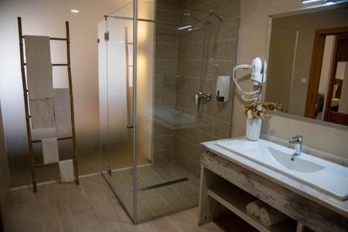 uma casa de banho com uma cabina de duche em vidro e um lavatório. em Hotel Marisol em Macedo de Cavaleiros