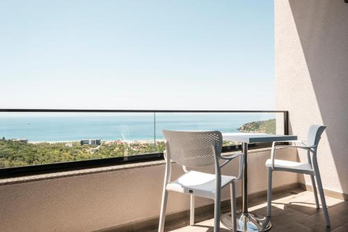 a table and chairs on a balcony with a view of the ocean at Wait 'n Sea in Himare