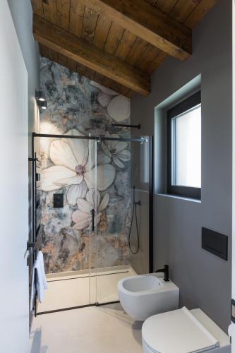 a bathroom with a walk in shower next to a toilet at Radici Luxury B&B in Monsampolo del Tronto