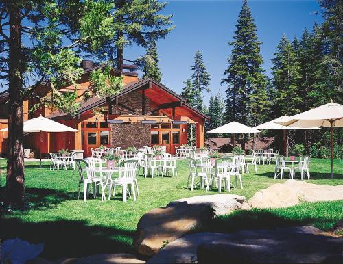a group of white chairs and umbrellas in front of a building at Granlibakken Tahoe in Tahoe City