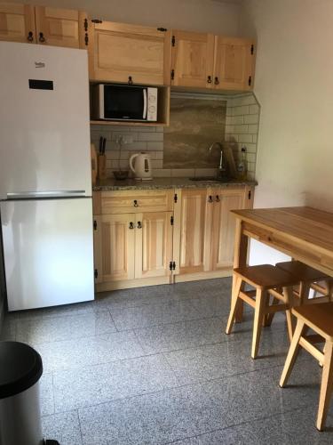 a kitchen with a white refrigerator and wooden cabinets at Osada Groń in Groń