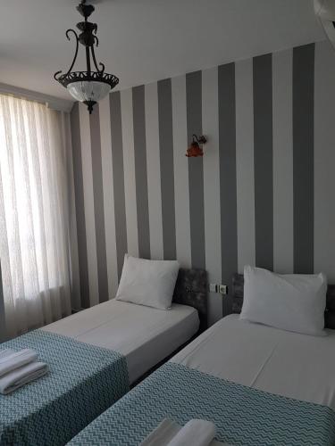two beds in a room with striped walls at LOTUS OTEL in Konya