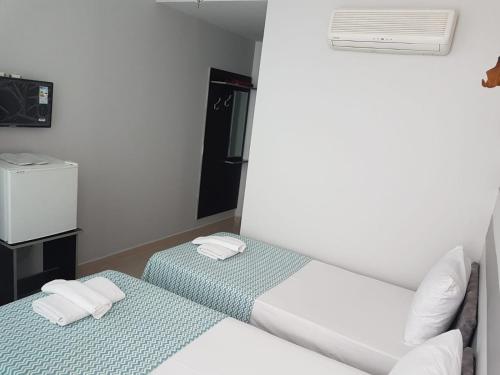 Habitación pequeña con 2 camas y paredes blancas. en LOTUS OTEL, en Konya