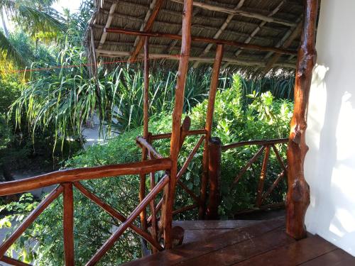 a wooden porch with a roof and some plants at Mount Zion Lodge in Michamvi