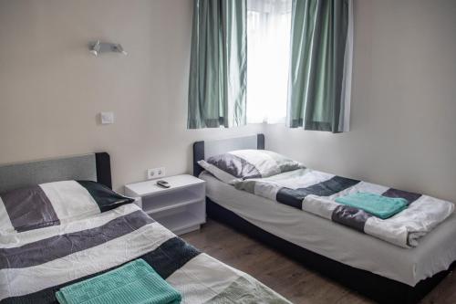 sypialnia z dwoma łóżkami i oknem w obiekcie Tempó Apartman Siófok w Siófoku