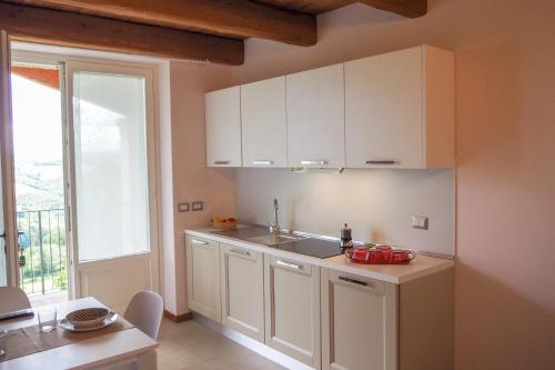 a kitchen with white cabinets and a sink and a window at Country House Ca'Balsomino in Urbino