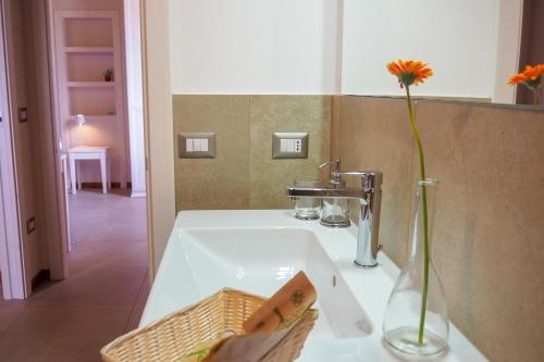a bathroom sink with a vase with a flower in it at Country House Ca'Balsomino in Urbino