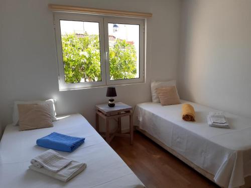 deux lits dans une chambre avec une fenêtre dans l'établissement MARSOL Beach Apartment, à Vilamoura