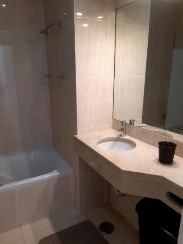 une salle de bain avec un lavabo, une baignoire et un miroir dans l'établissement MARSOL Beach Apartment, à Vilamoura
