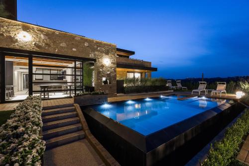 a swimming pool in the backyard of a house at night at Radici Luxury B&B in Monsampolo del Tronto