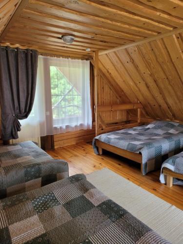 a bedroom with two beds in a log cabin at Miego klinika 2 -POILSIUI be triukšmo visą parą in Kelmė