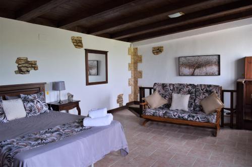 sypialnia z łóżkiem i kanapą w obiekcie Lo Maset de Laura w mieście Amposta