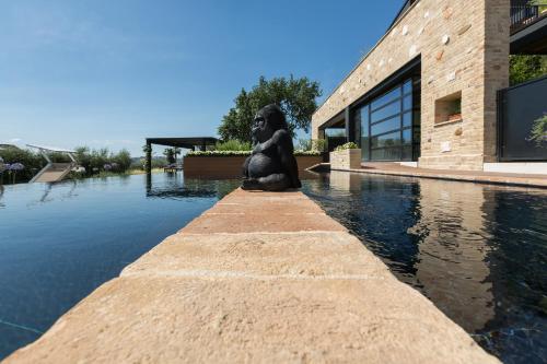 a statue sitting on the edge of a body of water at Radici Luxury B&B in Monsampolo del Tronto