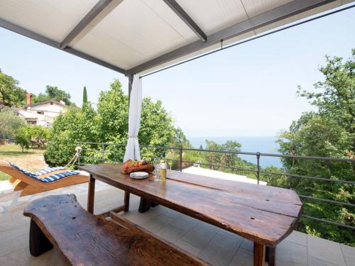a wooden table and bench on a balcony at Ferienhaus Baraka - Medveja in Lovran