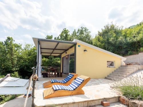 a house with two lounge chairs on a patio at Ferienhaus Baraka - Medveja in Lovran