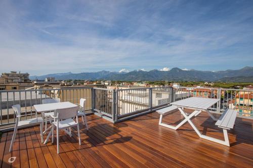a wooden deck with a table and chairs on a balcony at Beachfront Penthouse with private parking in Camaiore