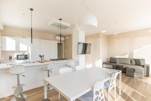 a kitchen and living room with a white table and chairs at Beachfront Penthouse with private parking in Camaiore
