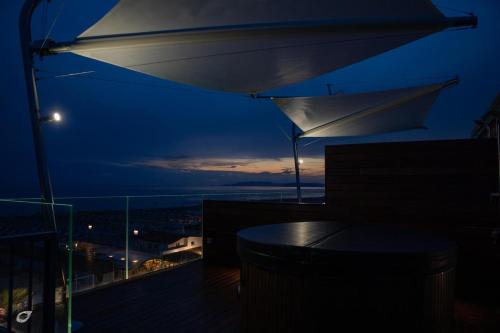 a night view of a balcony with a table and an umbrella at Beachfront Penthouse with private parking in Camaiore