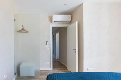 a bedroom with a blue bed and a white wall at Beachfront Penthouse with private parking in Camaiore