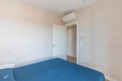 a bedroom with a blue bed and a white wall at Beachfront Penthouse with private parking in Camaiore