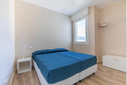 a white bedroom with a bed and a window at Beachfront Penthouse with private parking in Camaiore