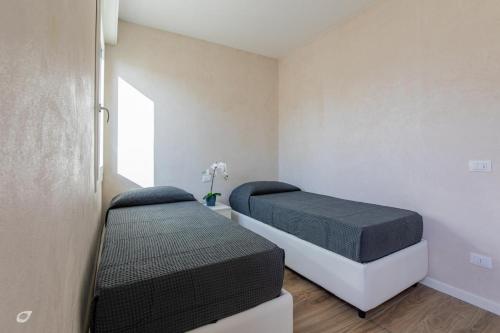 a bedroom with two beds and a window at Beachfront Penthouse with private parking in Camaiore
