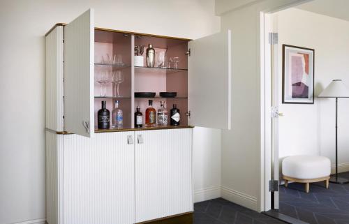 a room with a white cabinet with wine bottles at Kimpton Alton Fisherman's Wharf by IHG in San Francisco