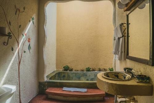 a bathroom with a sink and a bath tub at Hotel Toliman in San Lucas Tolimán