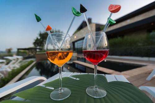two glasses of wine sitting on top of a table at Radici Luxury B&B in Monsampolo del Tronto