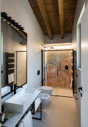 a bathroom with two sinks and a toilet and a shower at Radici Luxury B&B in Monsampolo del Tronto