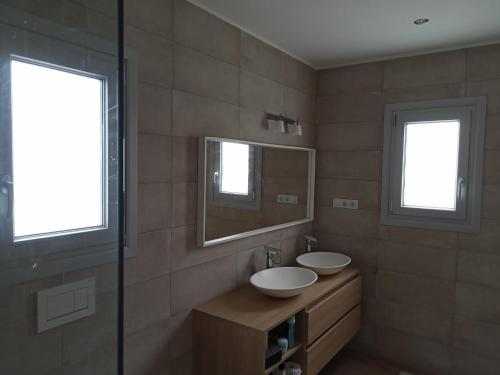uma casa de banho com dois lavatórios e dois espelhos em Villa Vista Volcan Lajares with heated pool em Lajares