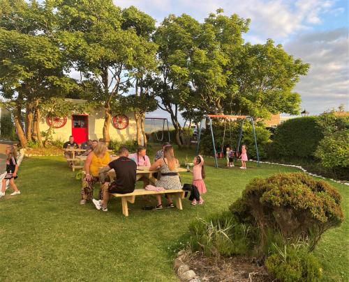 a group of people sitting on benches in a park at Atlantic Apartotel in Bundoran
